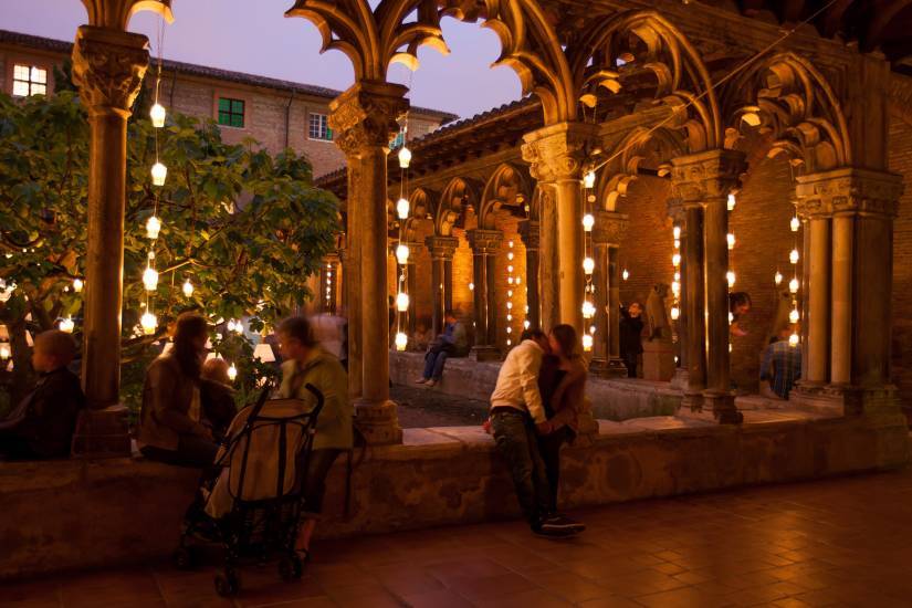 photo de nuit prise dans le cloitre d'un mus&eacute;e avec des visiteurs assis, l&eacute;g&egrave;rement flout&eacute;s