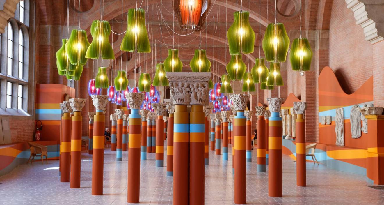 vue de la salle romane du musée des augustins à toulouse avec des grandes quilles colorées disposées de manière symétrique