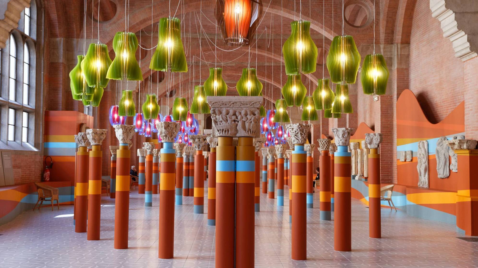 vue de la salle romane du musée des augustins à toulouse avec des grandes quilles colorées disposées de manière symétrique